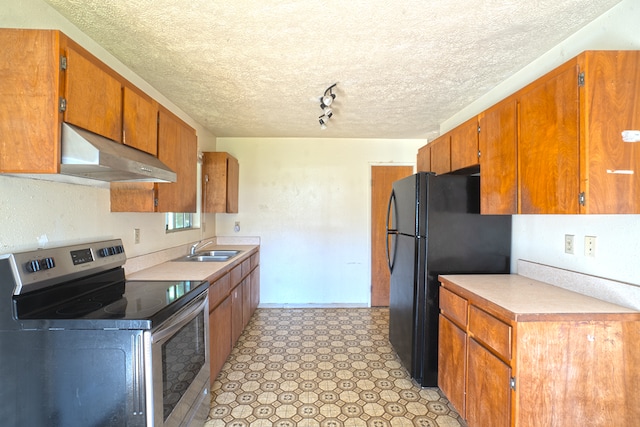 kitchen featuring black fridge, sink, stainless steel range with electric stovetop, a textured ceiling, and track lighting