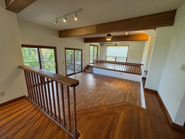 staircase with track lighting, beamed ceiling, hardwood / wood-style floors, and ceiling fan