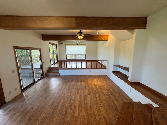 empty room with ceiling fan, beamed ceiling, and dark hardwood / wood-style floors