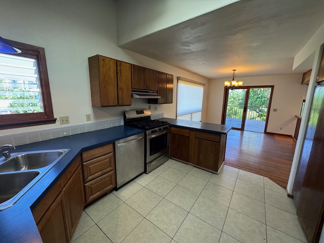 kitchen with a chandelier, light hardwood / wood-style flooring, sink, kitchen peninsula, and appliances with stainless steel finishes