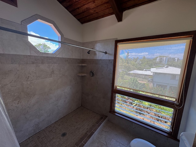 bathroom with lofted ceiling, a tile shower, and wooden ceiling