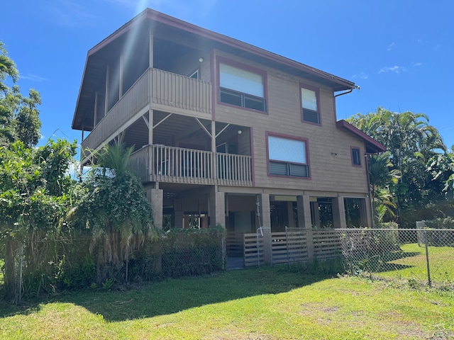 rear view of property with a balcony and a lawn