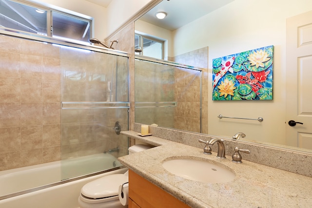 full bathroom with vanity, toilet, and shower / bath combination with glass door