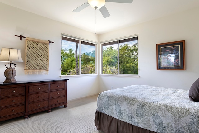 bedroom with light carpet, multiple windows, and ceiling fan