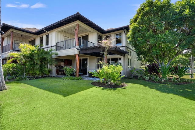 view of front of home featuring a balcony and a front lawn