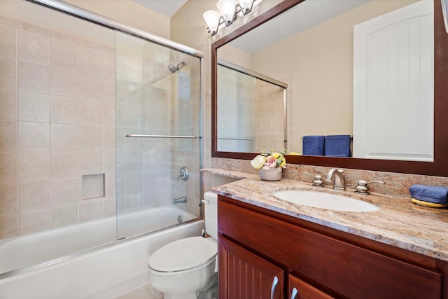 full bathroom featuring combined bath / shower with glass door, vanity, and toilet