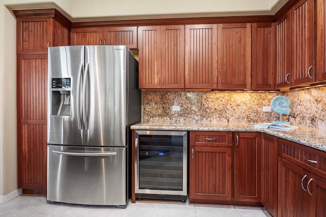 kitchen featuring beverage cooler, stainless steel refrigerator with ice dispenser, light stone counters, and tasteful backsplash