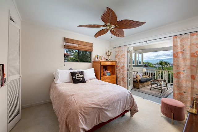 carpeted bedroom with ceiling fan, access to exterior, and ornamental molding