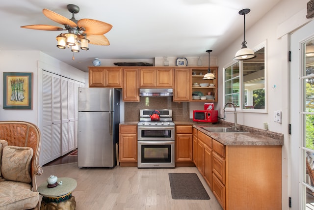 kitchen with light hardwood / wood-style floors, hanging light fixtures, sink, backsplash, and appliances with stainless steel finishes