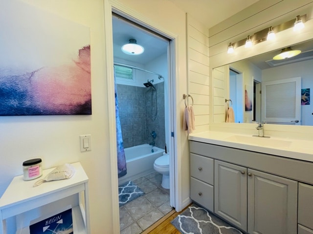 full bathroom with shower / tub combo, vanity, toilet, and hardwood / wood-style flooring