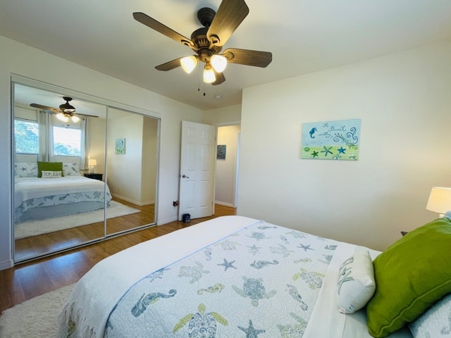 bedroom with hardwood / wood-style floors, a closet, and ceiling fan