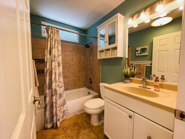 full bathroom with shower / bath combination with curtain, tile patterned floors, vanity, and toilet