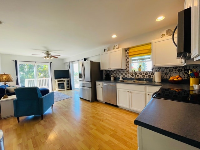 kitchen featuring a wealth of natural light, white cabinetry, appliances with stainless steel finishes, and sink