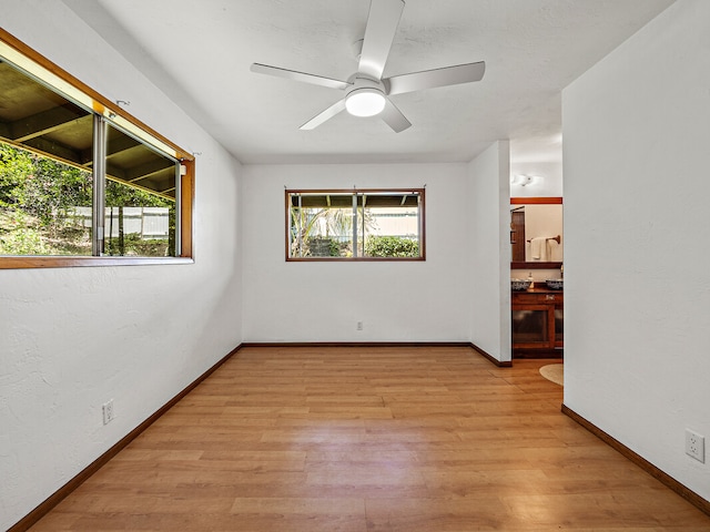 spare room with ceiling fan and light wood-type flooring