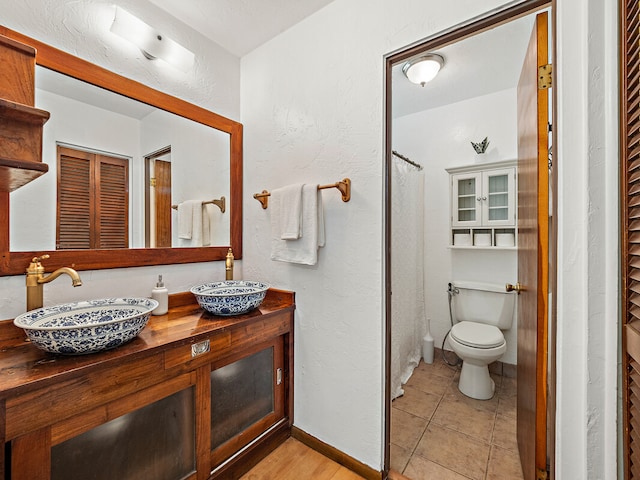 bathroom with vanity, walk in shower, tile patterned floors, and toilet