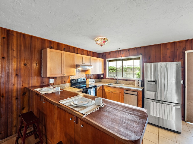 kitchen featuring light tile patterned floors, sink, stainless steel appliances, and kitchen peninsula