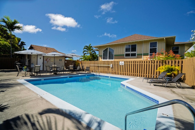 pool featuring fence and a patio area