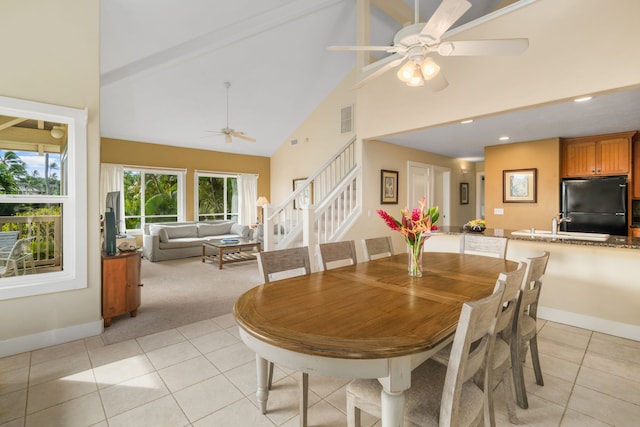 dining space with ceiling fan, light tile patterned floors, and high vaulted ceiling