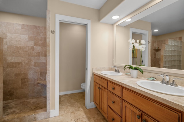 bathroom featuring vanity, toilet, and tiled shower