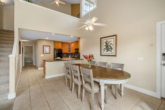 tiled dining area featuring ceiling fan and high vaulted ceiling