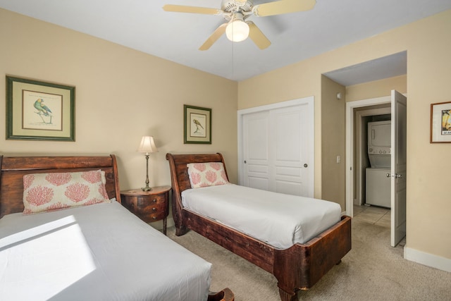 bedroom featuring light colored carpet, ceiling fan, and a closet