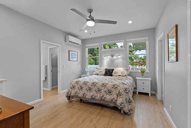 bedroom with a wall mounted AC, light wood-type flooring, and ceiling fan