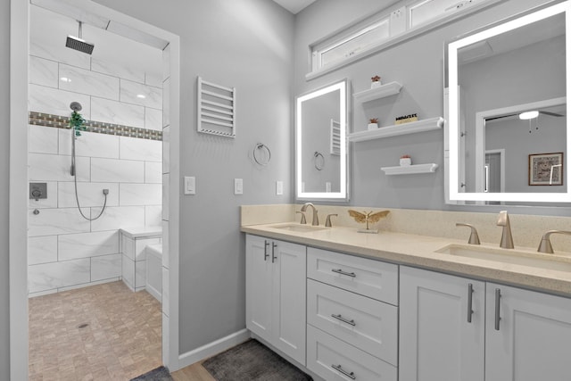 bathroom with a tile shower and vanity