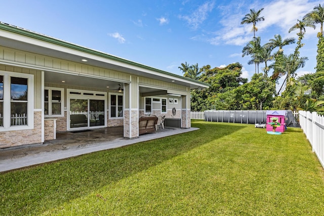 view of yard featuring an outdoor living space, ceiling fan, and a patio area