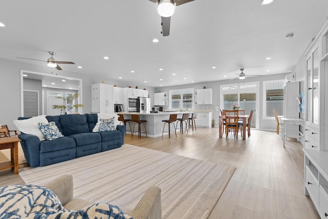 living room featuring ceiling fan and light wood-type flooring