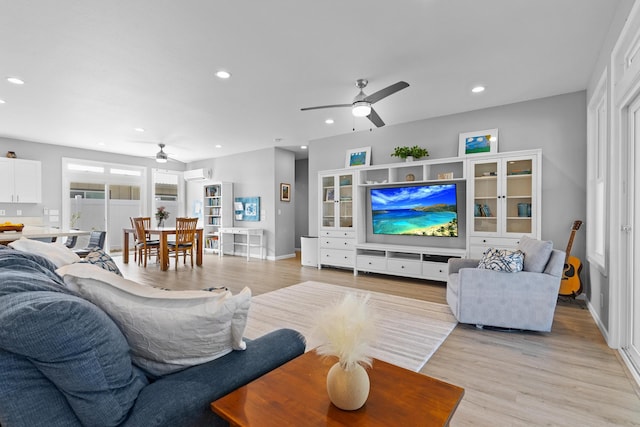 living room featuring ceiling fan and light hardwood / wood-style floors