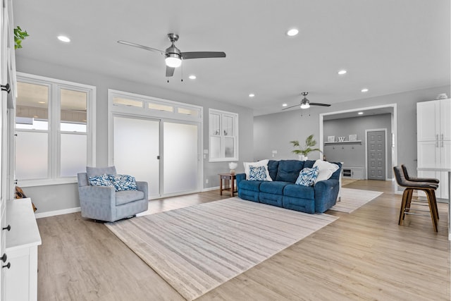 living room with light hardwood / wood-style flooring and ceiling fan