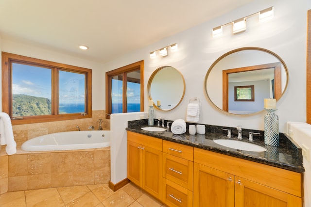 bathroom featuring tile patterned floors, vanity, and tiled bath