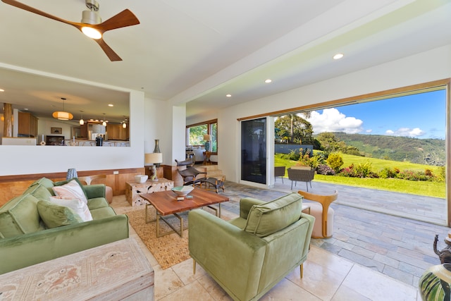 living room with a mountain view and ceiling fan