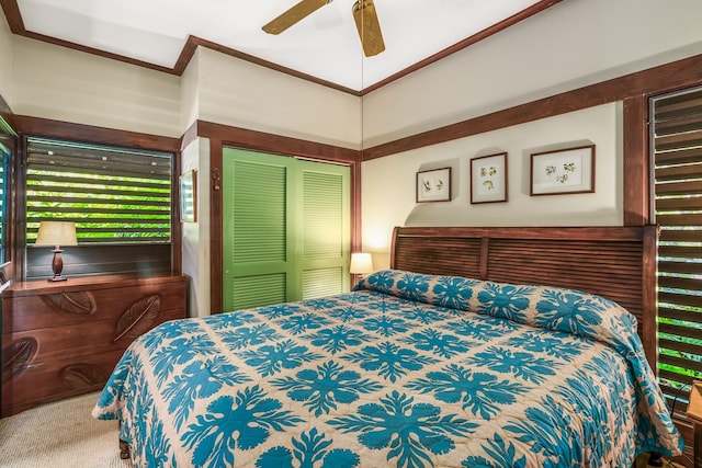 carpeted bedroom featuring ceiling fan and a closet