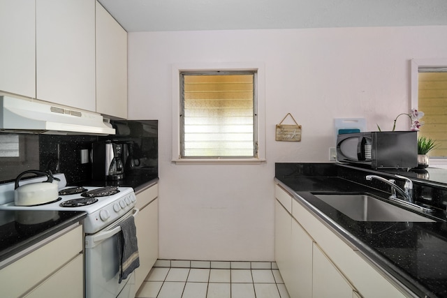 kitchen featuring light tile patterned floors, sink, white cabinetry, white electric range, and dark stone countertops