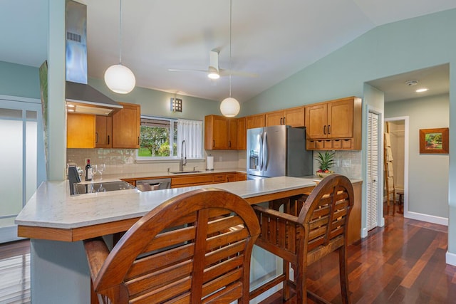 kitchen featuring kitchen peninsula, decorative backsplash, stainless steel appliances, sink, and pendant lighting