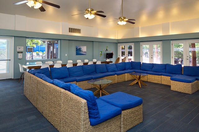 carpeted living room featuring a high ceiling, ceiling fan, and french doors