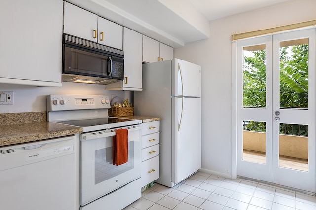 kitchen featuring light tile patterned flooring, white appliances, and white cabinetry