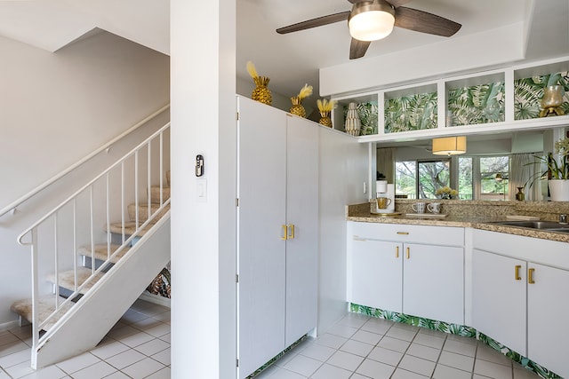 kitchen with ceiling fan, white cabinets, and light tile patterned flooring