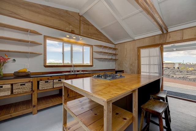 kitchen with vaulted ceiling with beams, stainless steel gas stovetop, and sink