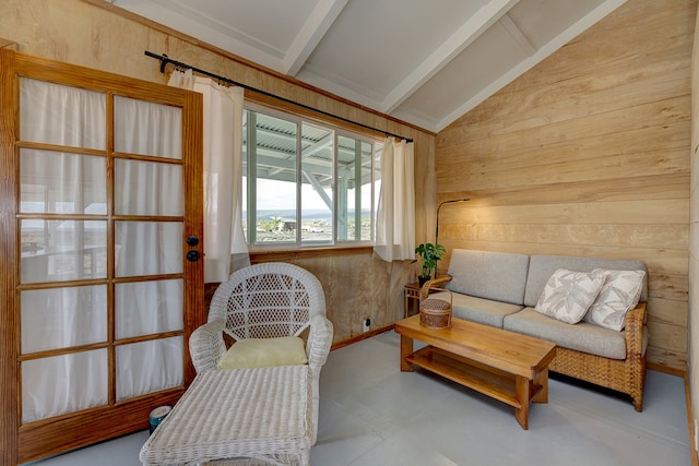 living area featuring lofted ceiling with beams and wood walls