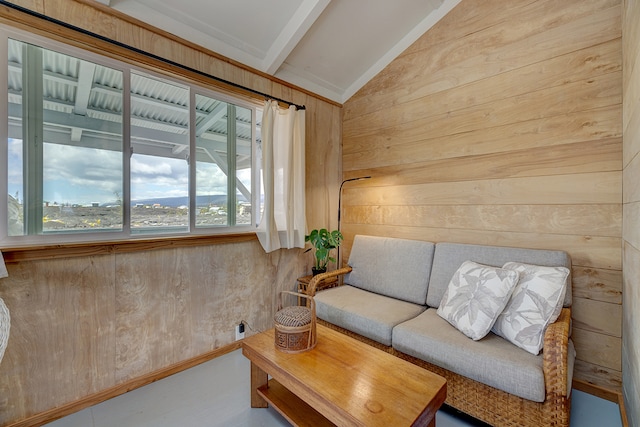 living area with vaulted ceiling with beams and wood walls