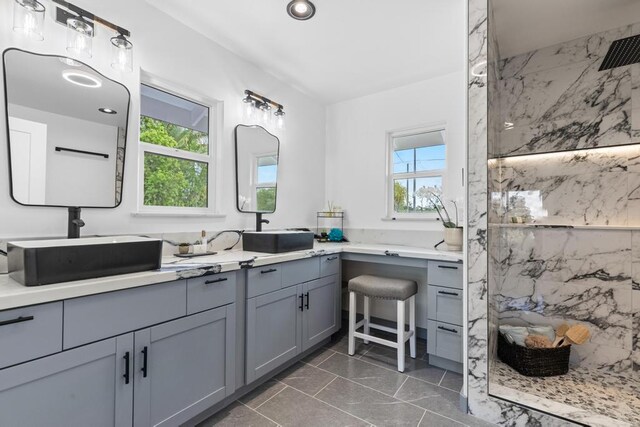 bathroom with vanity, a tile shower, and tile patterned floors