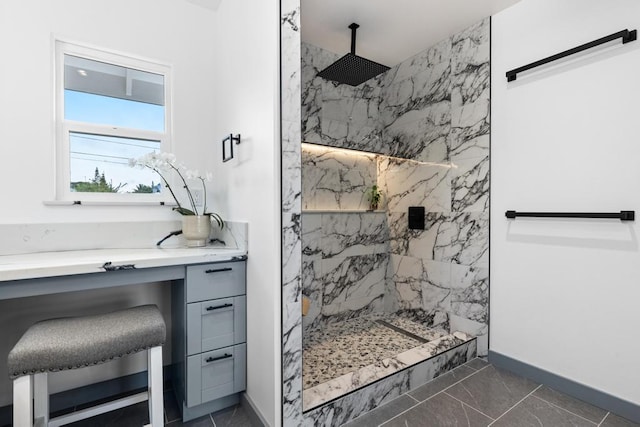 bathroom featuring vanity, tile patterned flooring, and a tile shower