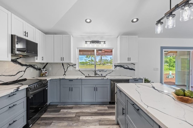 kitchen featuring hanging light fixtures, gray cabinetry, backsplash, and stainless steel appliances