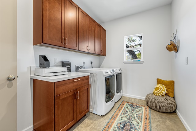 clothes washing area featuring light tile patterned flooring, cabinets, and washing machine and dryer