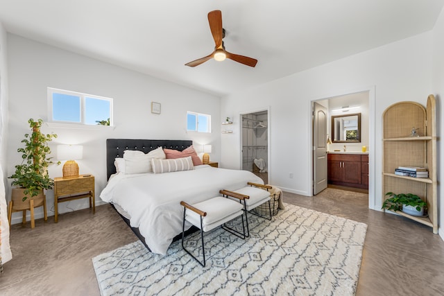 bedroom with ensuite bath, a closet, a spacious closet, and ceiling fan