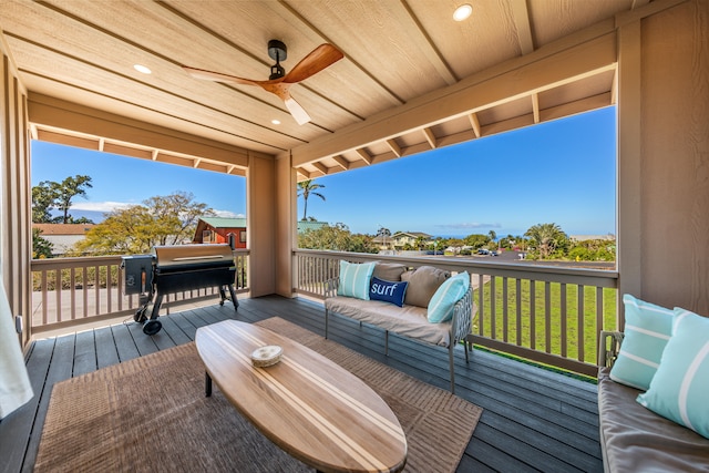 deck with outdoor lounge area, a yard, grilling area, and ceiling fan