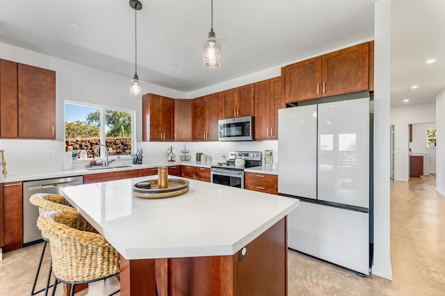 kitchen featuring sink, a center island, a kitchen breakfast bar, pendant lighting, and appliances with stainless steel finishes