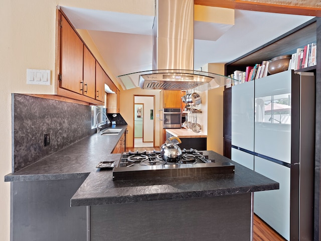 kitchen with decorative backsplash, stainless steel appliances, island exhaust hood, hardwood / wood-style flooring, and sink